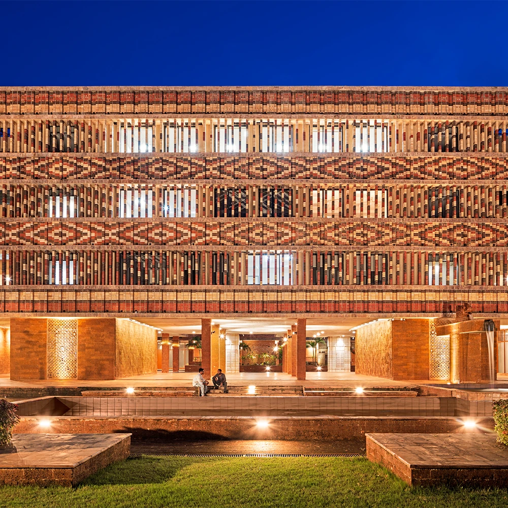 Night view of Krishi Bhawan's signature brick facade and adjacent forecourt with left and right lily ponds framing the entrance to the main veranda